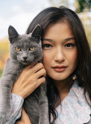 飼主溫柔抱著貓咪，展現穩定陪伴與日常觀察對貓咪防禦力的重要性