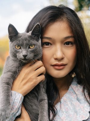 飼主溫柔抱著貓咪，展現觀察貓咪口腔異狀與陪伴就醫的重要性